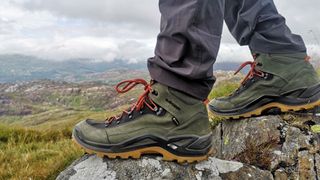 Man standing on rocks wearing Lowa Renegade hiking boots