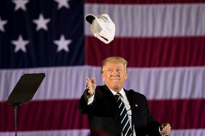 President Trump throwing Make America Great Again hat.