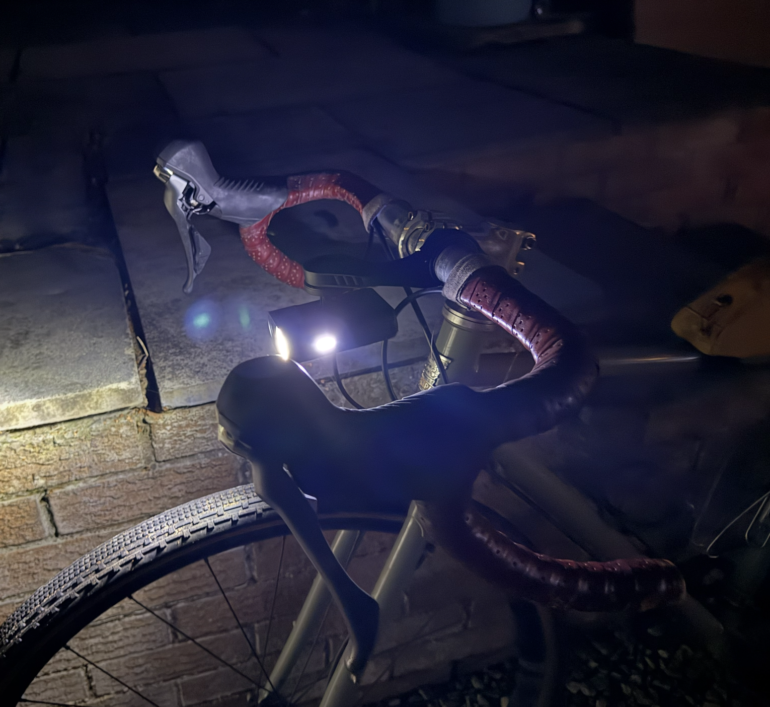 A bike light in the dark, lit up with a little indicator light on the edge.