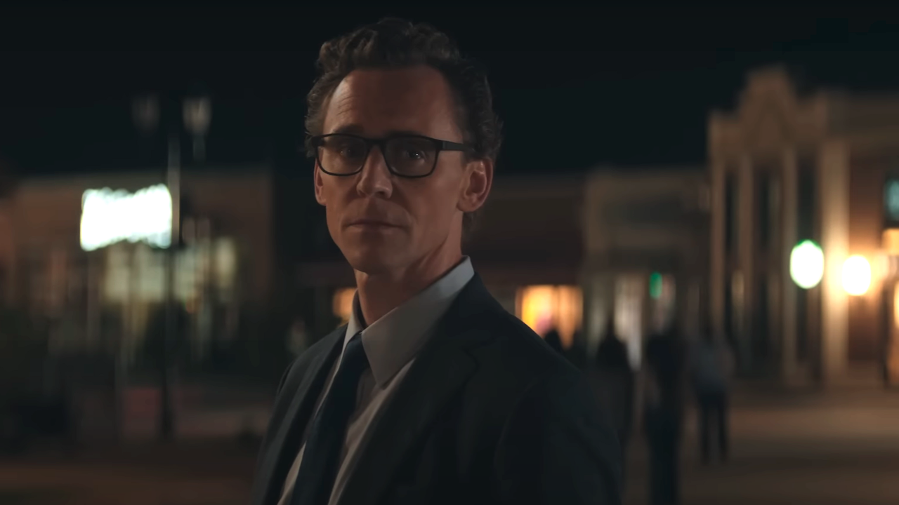 Tom Hiddleston looking out while at a town square at night in The Life Of Chuck