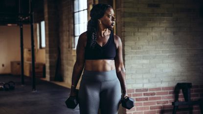 Woman carrying two dumbbells