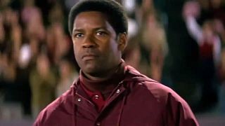 Coach Herman Boone (Denzel Washington) watching from the sideline in Remember the Titans