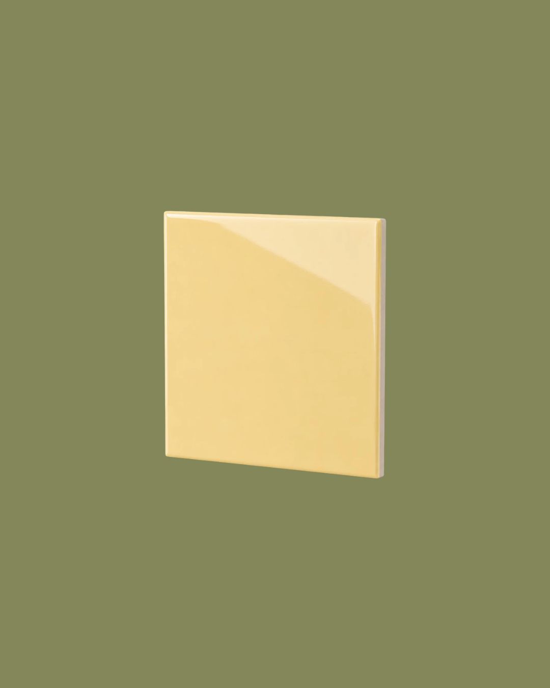 A yellow glossy tile against dark background.