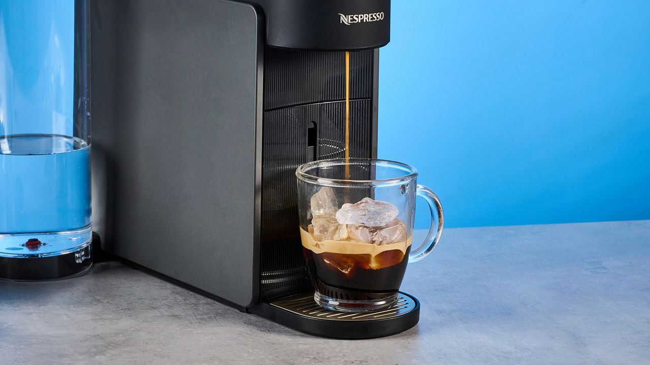 the nespresso vertuo up machine photographed against a blue background