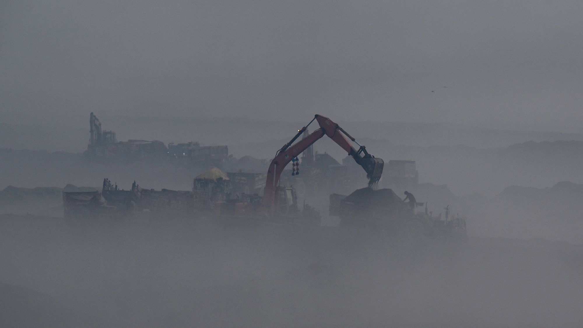 Construction vehicles are seen operating amid heavy smog in Lahore, Pakistan
