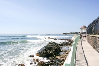 People walk along the ocean on the Cliff Walk in Newport, Rhode Island