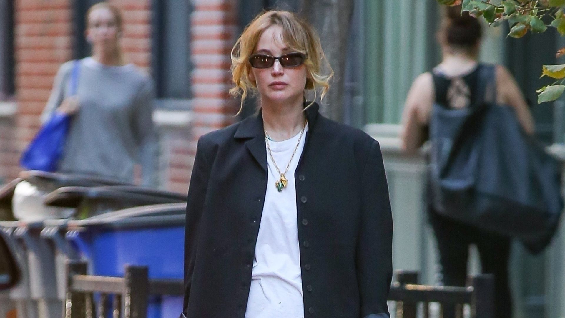 Jennifer Lawrence walks through New York wearing a black midiskirt with black ballet flats and a black single breasted jacket.
