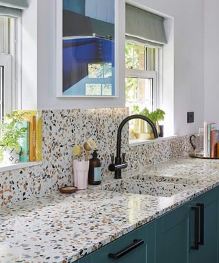 A modern kitchen with Terazzo motif countertop and backsplash with black mixer faucet