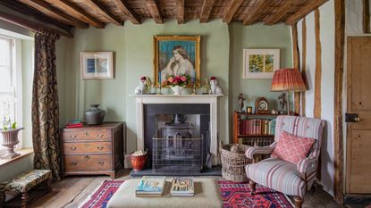 Living room in a tudor house with beamed ceiling, traditional fireplace and chair beside