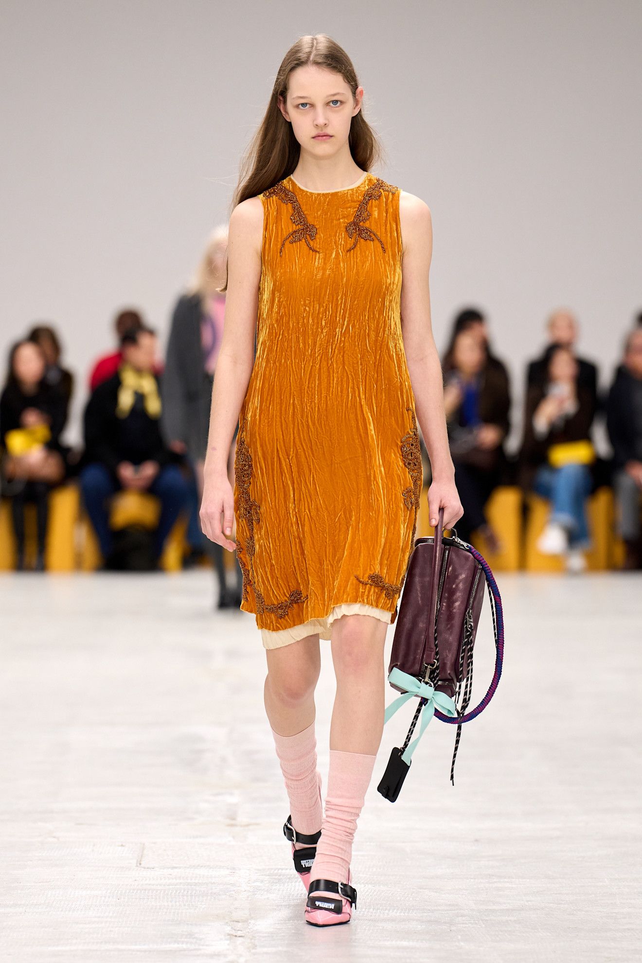 A model wore orange and plum on Onitsuka Tiger's Fall 2026 runway
