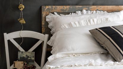 Ruffled pillows on a bed with a chair