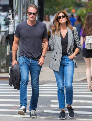 Cindy Crawford wears a plaid blazer with a black t-shirt and jeans.