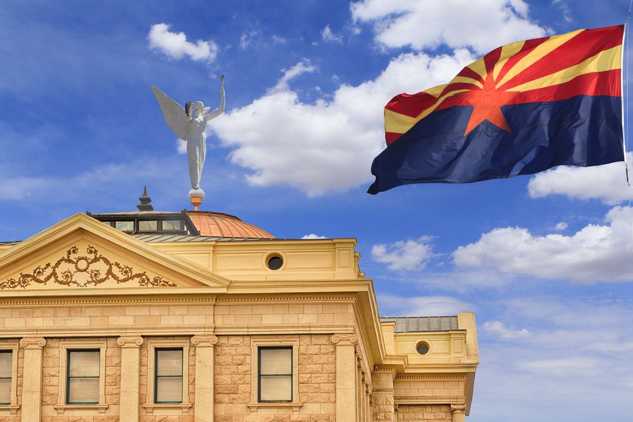 Arizona capitol building with the state flag flying above 