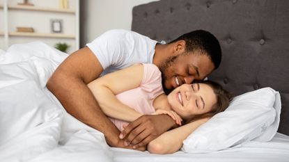 Couple cuddling in bed at home