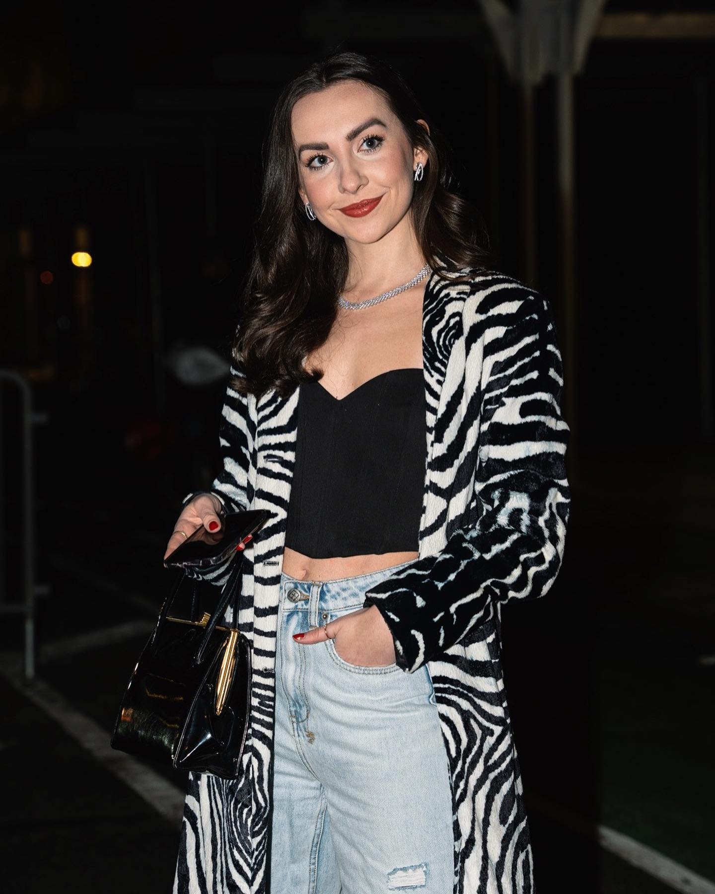 kendall wears black bustier, zebra duster, and light wash ripped jeans with a black top-handle bag.