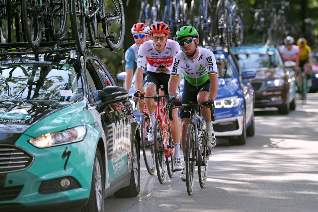 Mark Cavendish rides in the cars after a flat tyre during stage 2 in Poland
