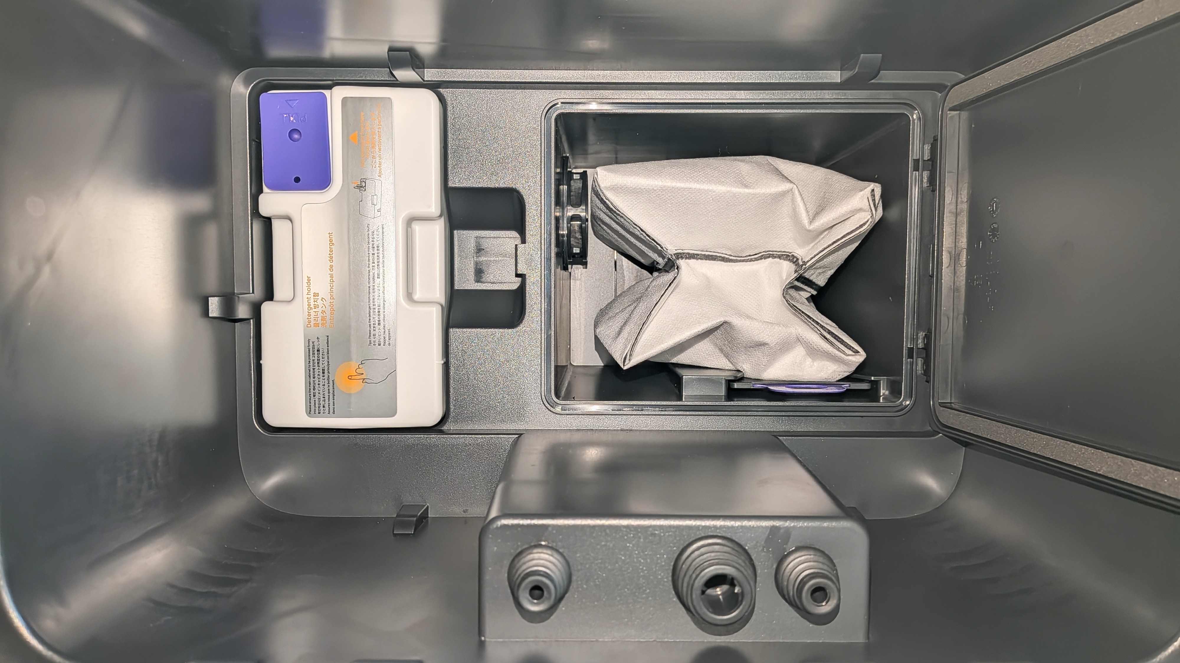 Inside the Narwal Flow 2 robot vacuum's charging dock, with bag and cleaning solution containers