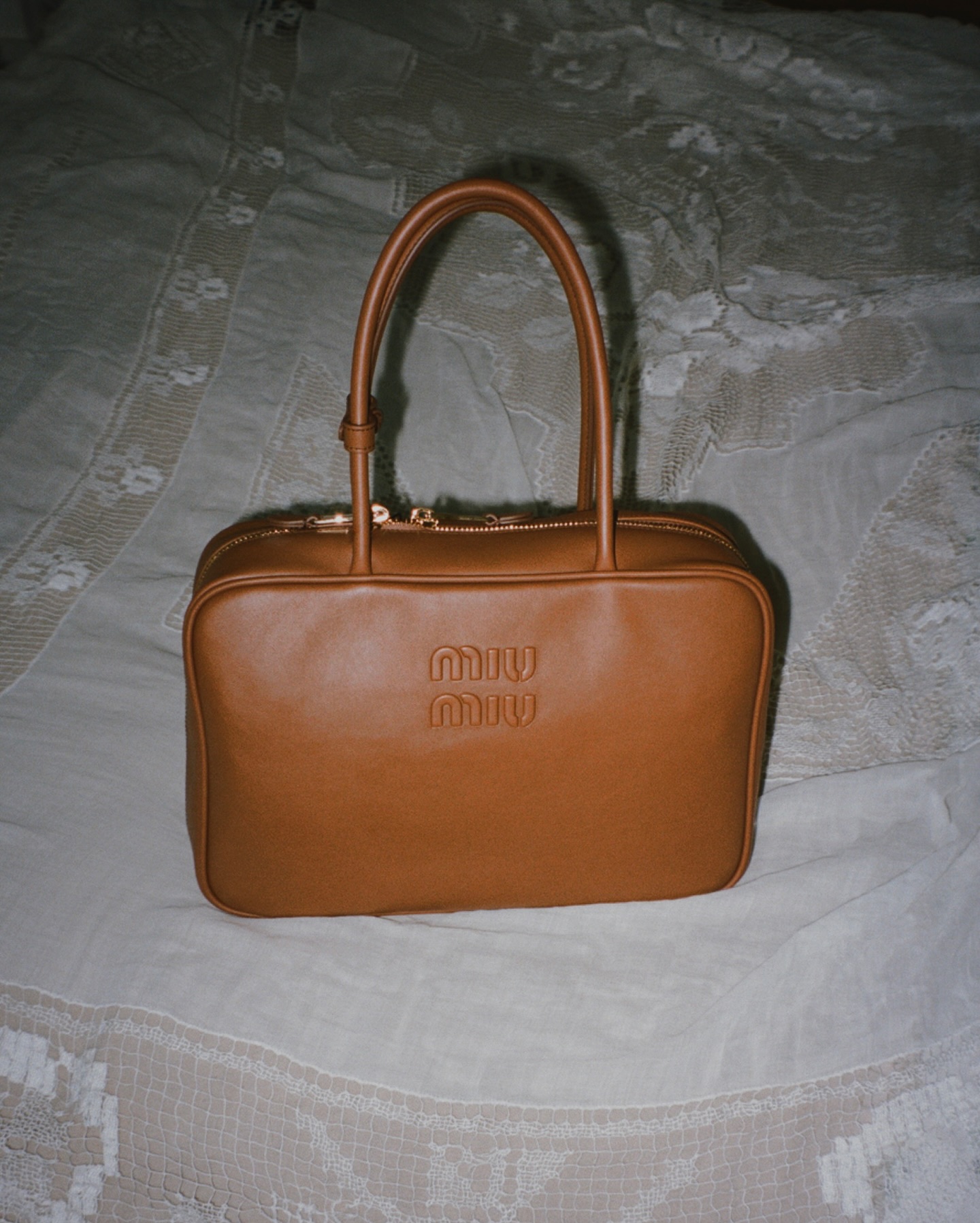 An image of @alicezielasko with the Miu Miu Beau bag in tan, an example of the doctor&#039;s bag trend.