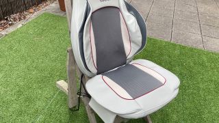Beurer MG320 massage seat pad on a chair, in a garden