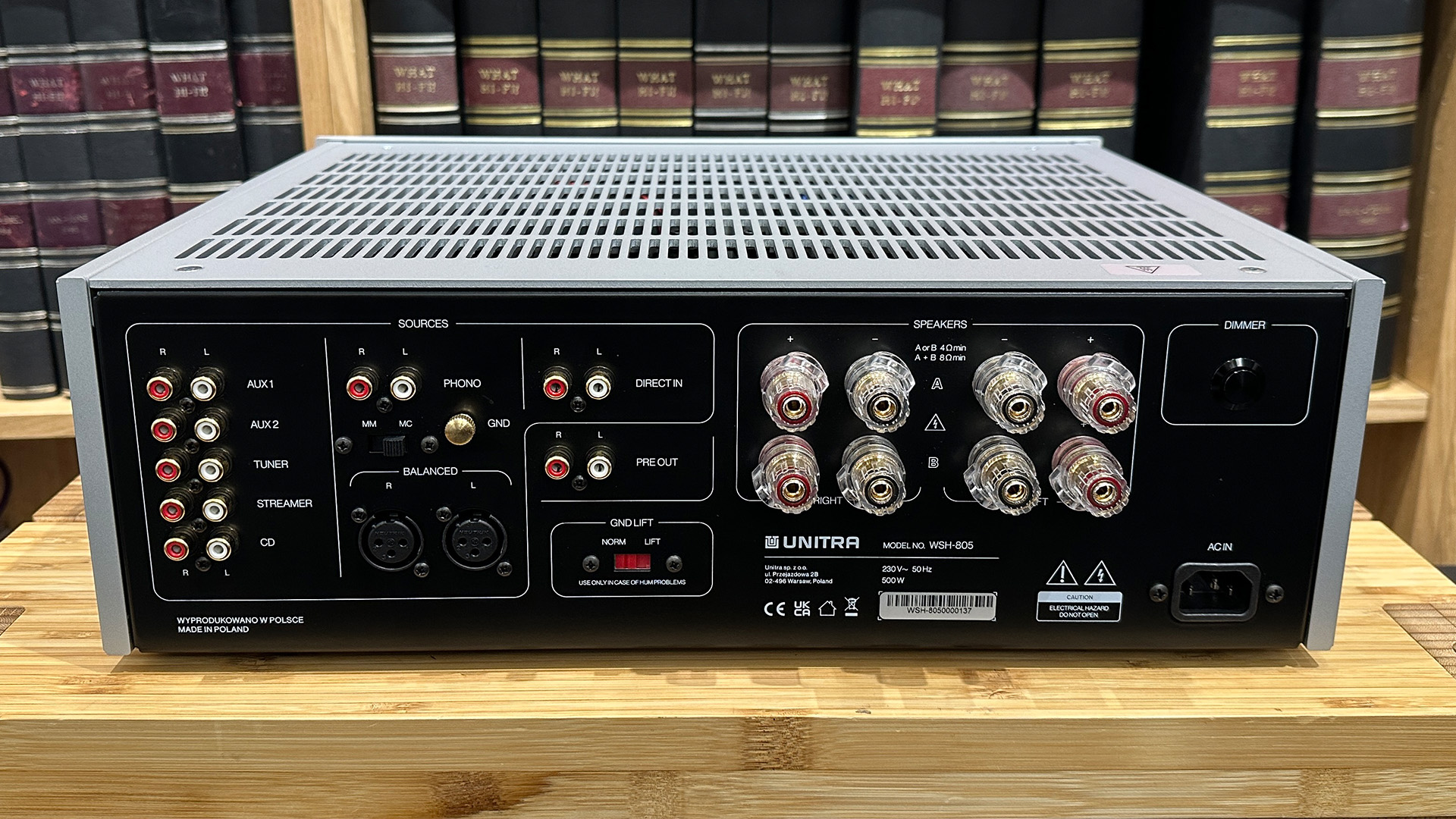 Unitra WSH-805 integrated amplifier on wooden hi-fi rack in front of bookcase rear of unit showing connections