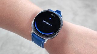 Close-up of the Samsung Galaxy Watch 8 on the writer's wrist showing the Gemini AI assistant feature
