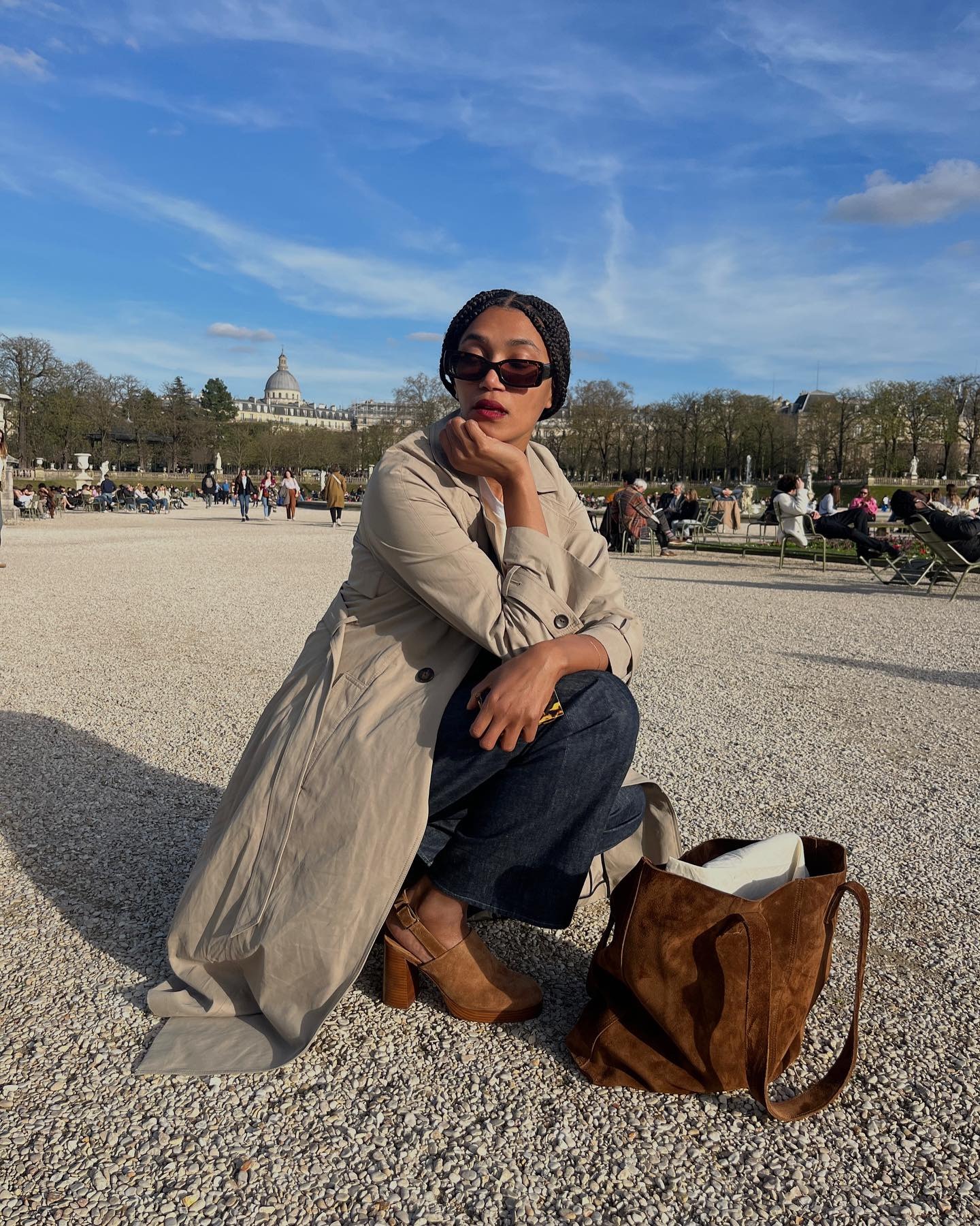 Influencer Lena wears a trench coat with jeans and a pair of suede clogs.