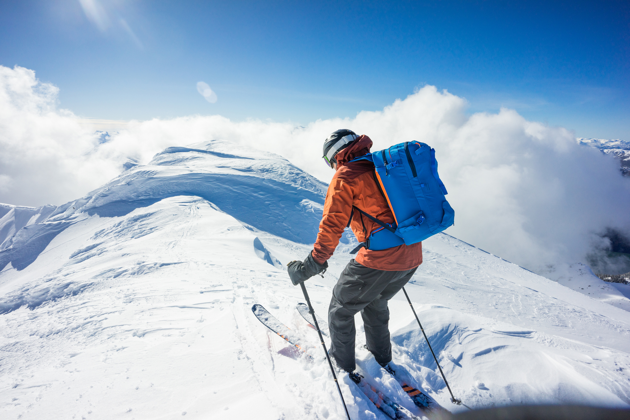 Backcountry skier preparing to descend mountain summit