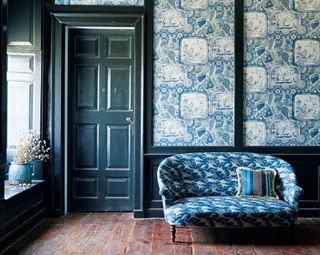 Blue small sofa with swallows, blue patterned wallpaper
