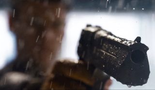 An obscured figure aiming a gun in The Matrix Resurrections.