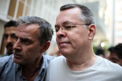 US pastor Andrew Craig Brunson (R), escorted by Turkish plain clothes police officers arrives at his house on July 25, 2018 in Izmir. - Turkey on July 15, 2018 moved from jail to house arrest