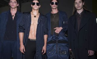 4 male models wearing clothing in different shades of navy