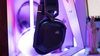 Corsair HS80 RGB Wireless on a white table with RGB background