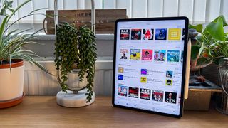 A photograph of the 12.9in Apple iPad Pro on table with some plants 