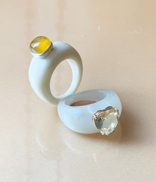 chunky white rings, one with yellow stone, one with clear stone