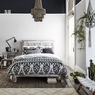 Monochrome bedroom with wooden flooring and chandelier