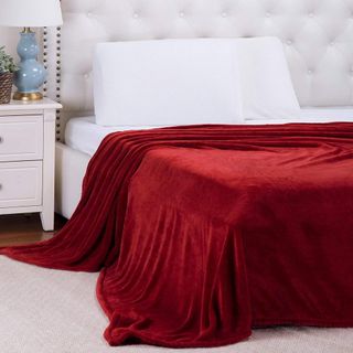 bedroom with white headboard and white cushion and red throw