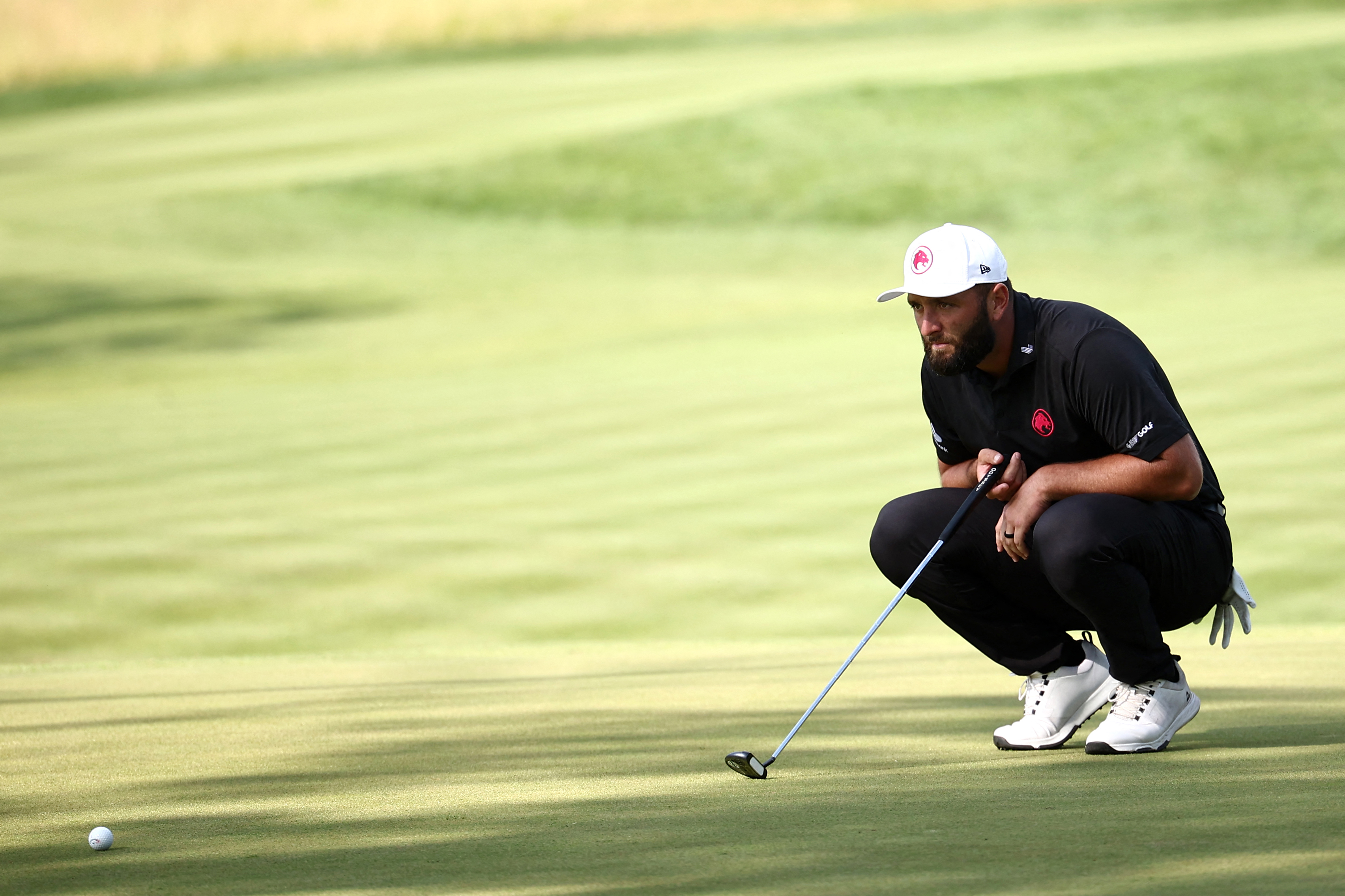 Jon Rahm lines up a putt at JCB Golf & Country Club at LIV Golf UK in 2024