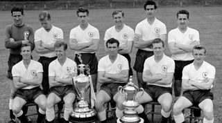 The Double winning Tottenham Hotspur football team pose with the League Championship and FA Cup trophies at their training ground. Back row left to right: Bill Brown, Ron Henry, Peter Baker, Danny Blanchflower, Maurice Norman, Dave Mackay. Front row left to right: Cliff Jones, John White, Bobby Smith, Les Allen, and Terry Dyson. 4th August 1961. (Photo by George Greenwell/Daily Mirror/Mirrorpix via Getty Images)