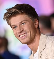 Robert Irwin in a white T-shirt and beige suit jacket attends the Premiere of Walt Disney Studios' "Zootopia 2" at El Capitan Theatre on November 13, 2025 in Los Angeles, California