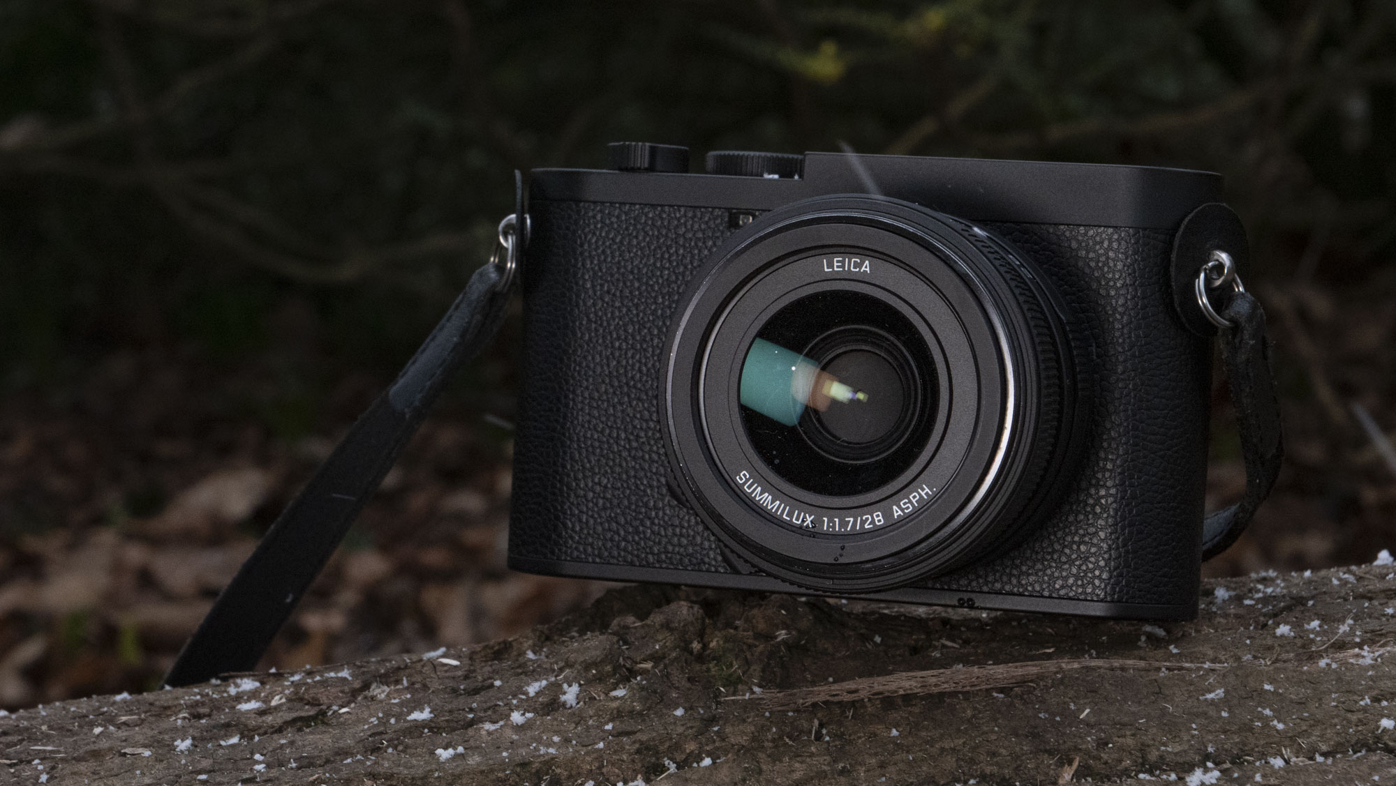 Leica Q3 Monochrom compact camera outside on a snow-dusted log
