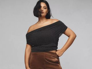 Model wears off the shoulder polka dot top and brown barrel leg pants.