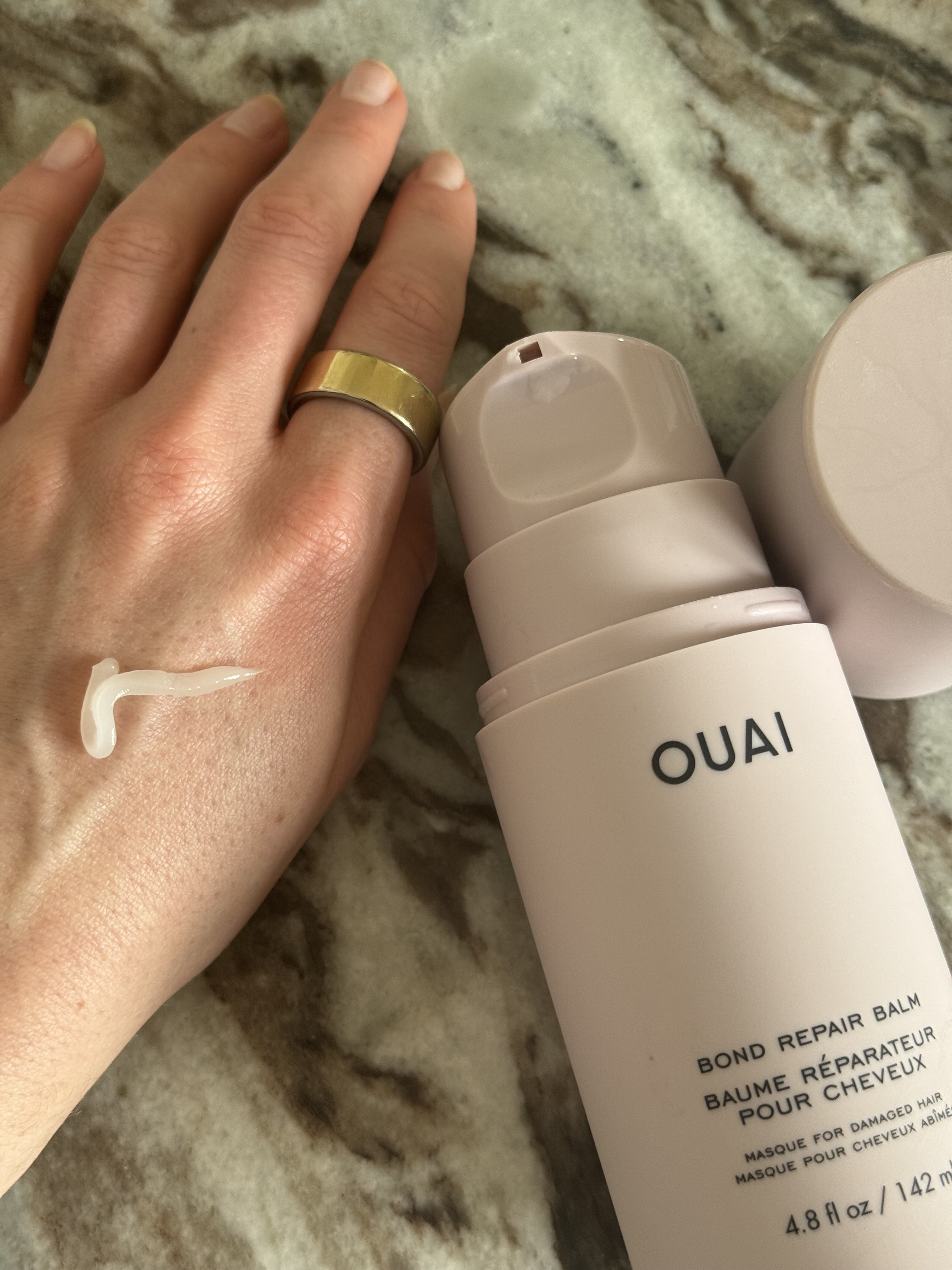 The Ouai bond repair balm texture on the back of a hand
