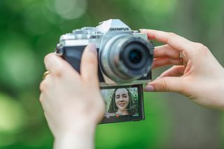 Olympus OM-D E-M10 Mark IV shown with the front facing screen