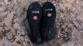 The soles of a pair of Unparallel Up Lace climbing shoes.