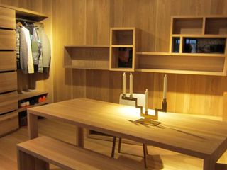 A completely wooden room with a table, benches and shelves