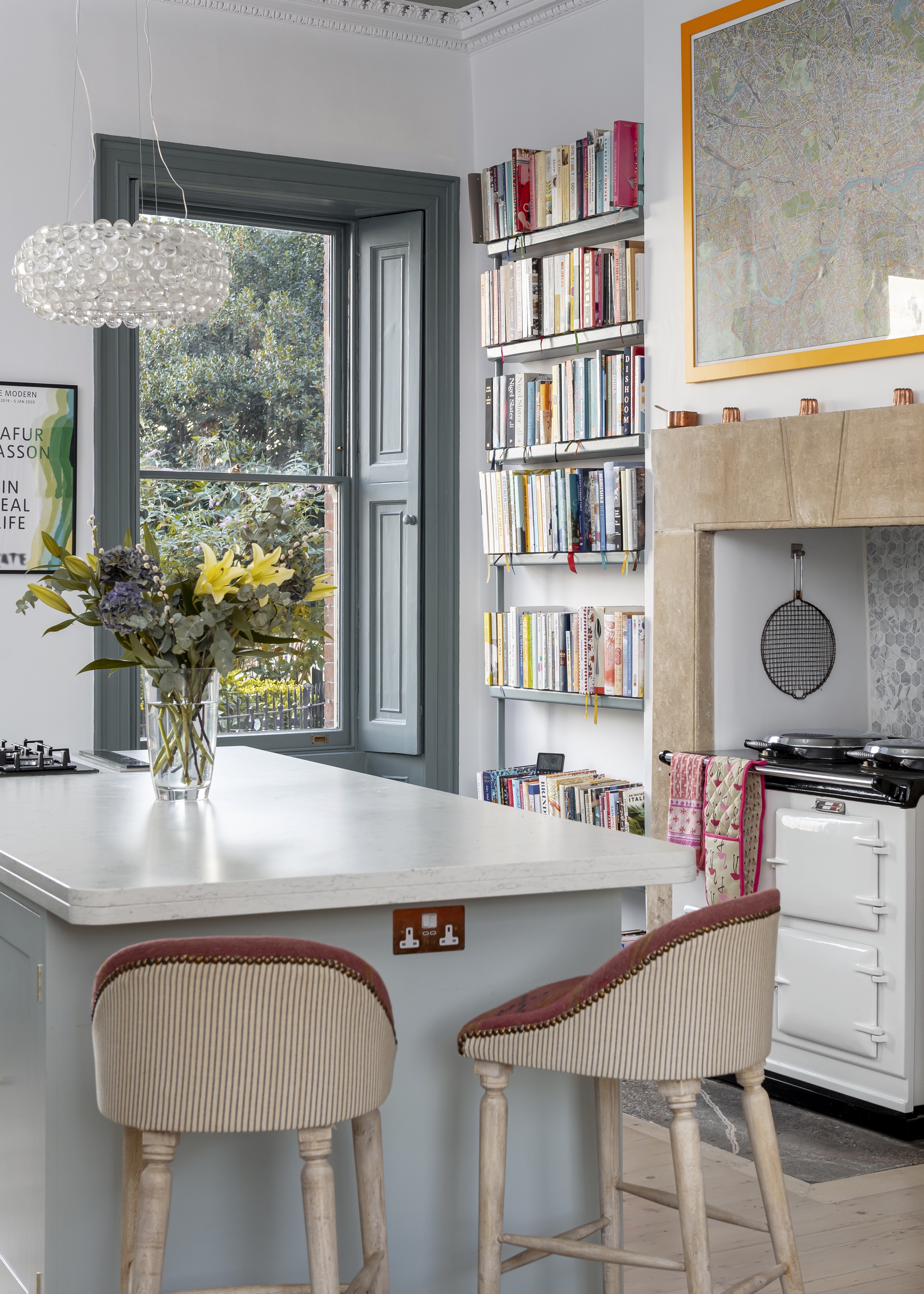 grey kitchen with bookshelf and striped bar stools