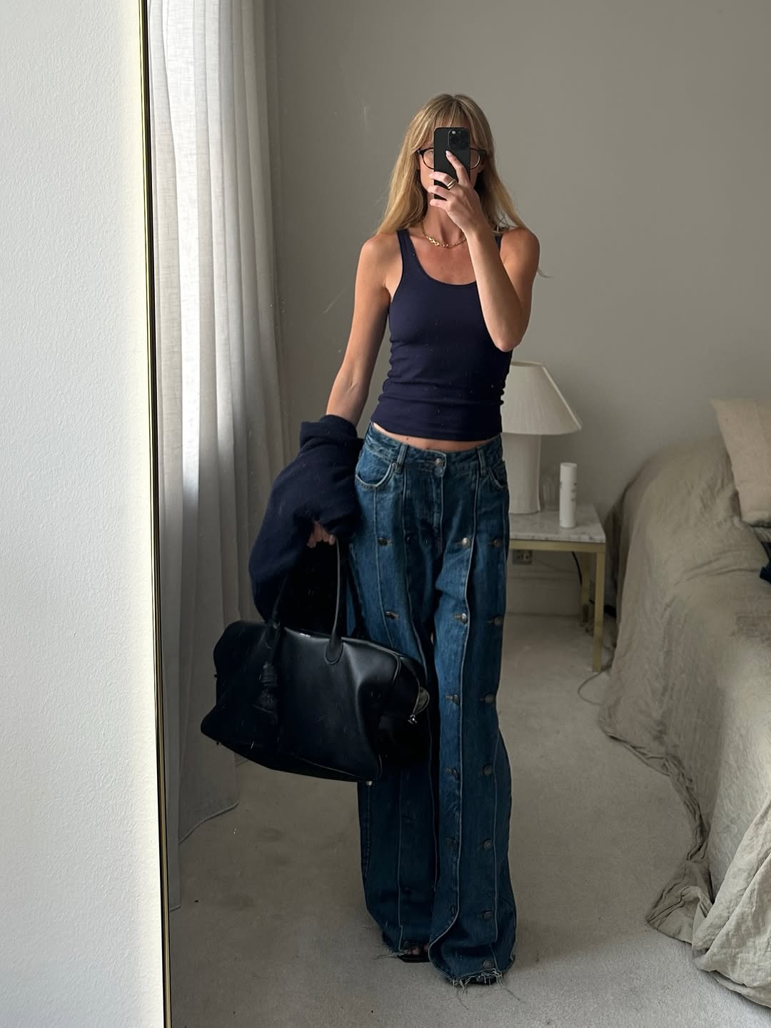 Woman wearing long, baggy jeans fall denim trend 2025.