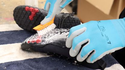 Person scrubbing a shoe using soapy water