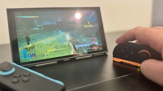 A picture of a Nintendo Switch 2, in mouse mode, with Cyberpunk 2077 in the background