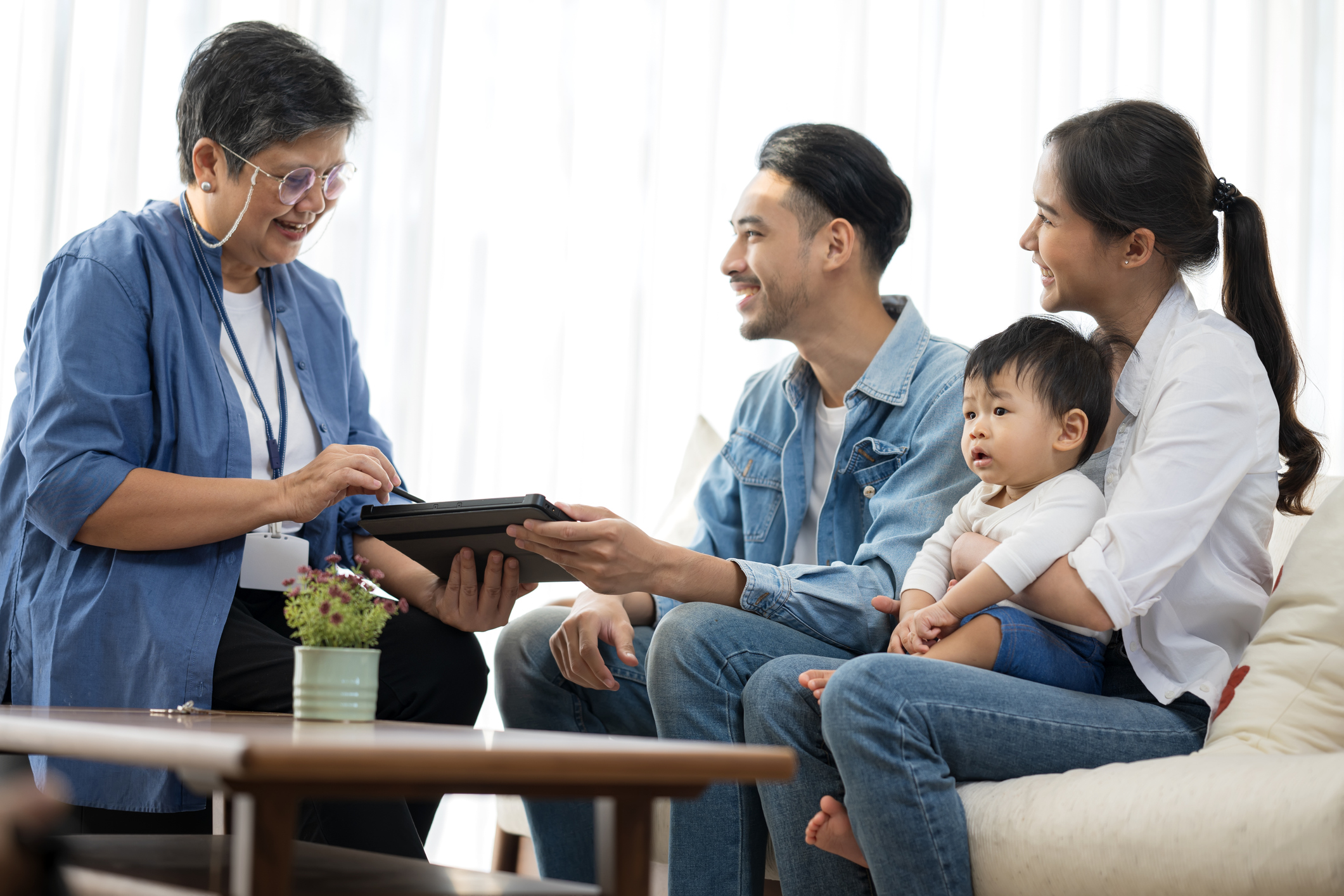 An adviser explains what is life insurance to a couple with a baby in their living room.